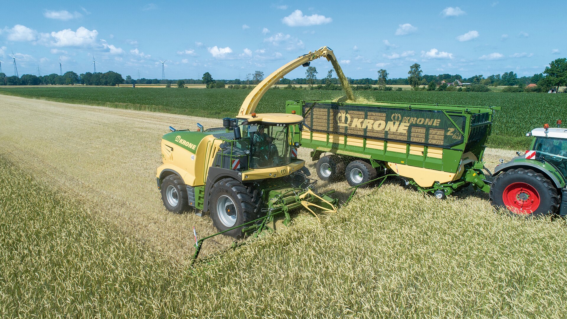 Mähdrescher und Traktor mit Anhänger arbeiten auf Feld